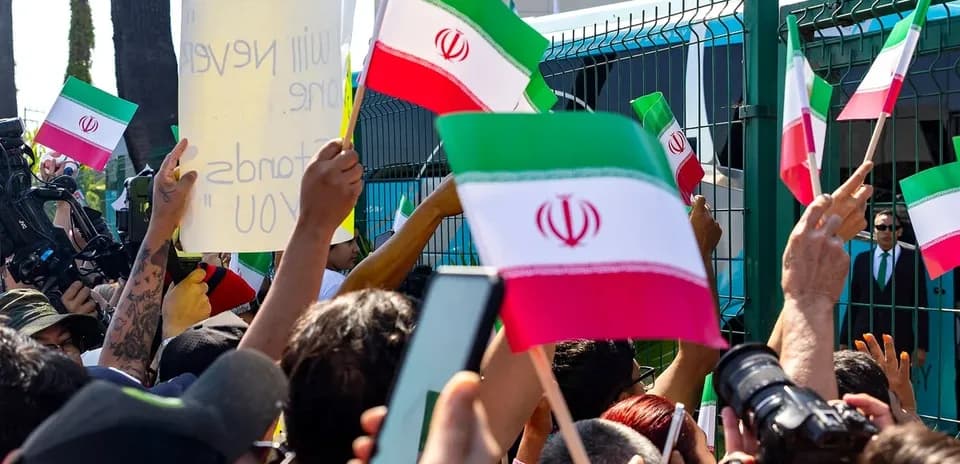 Crowd holding Iranian flags and signs at protest