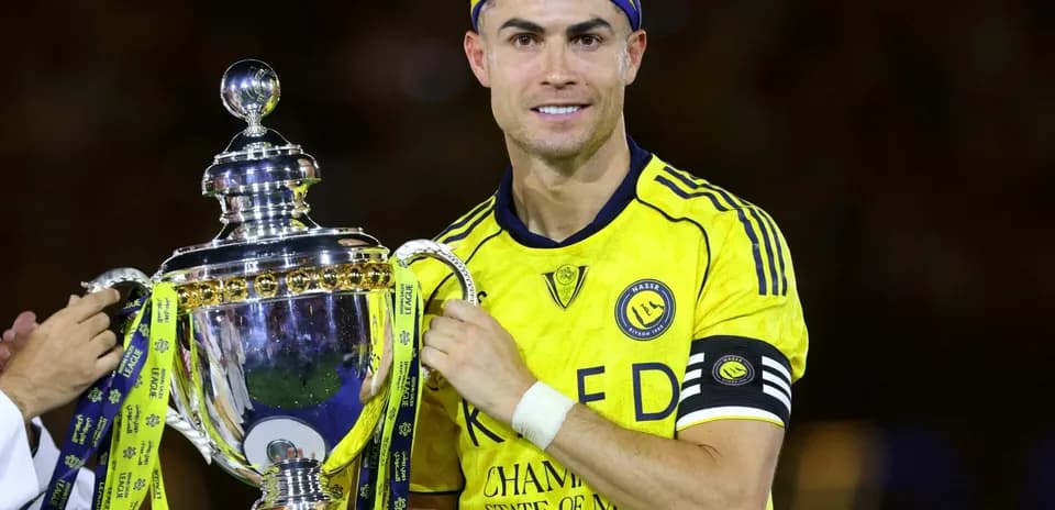 Player holding trophy in yellow team jersey
