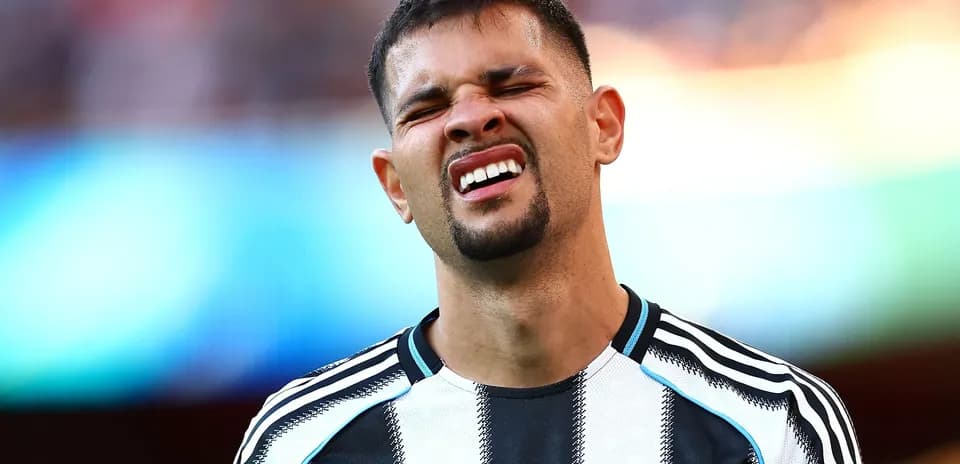 Player grimacing during a match in black and white kit