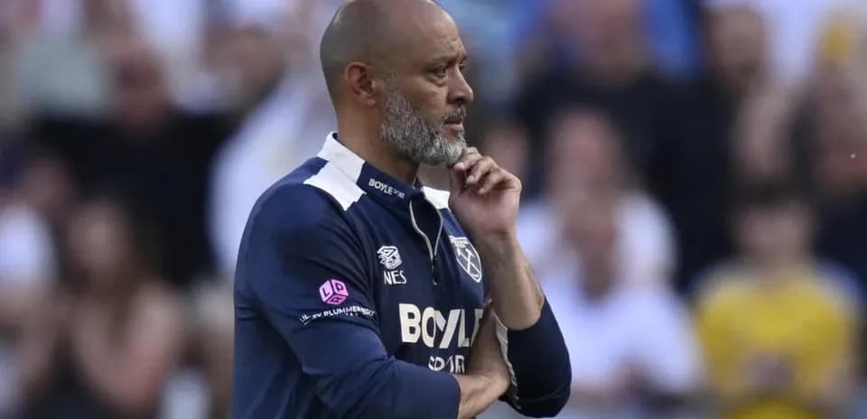 Manager observing the match with thoughtful expression
