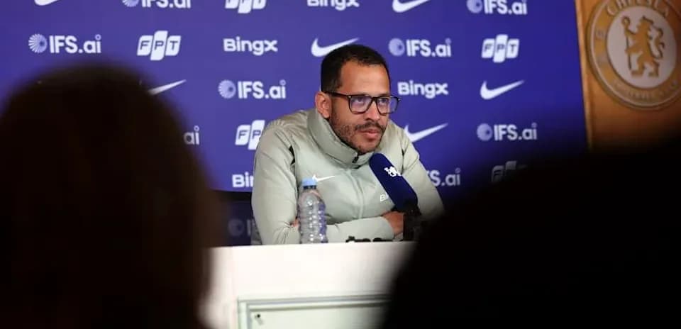 Manager speaking at press conference with Chelsea backdrop