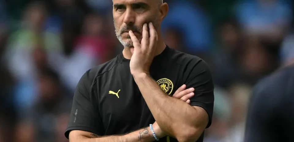 Coach observing the match with a thoughtful expression