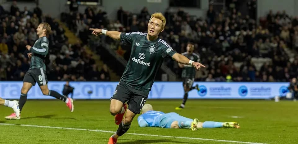Player celebrating a goal with teammates in match