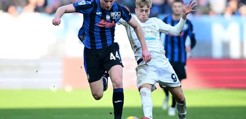 Cagliari player challenging Atalanta opponent for the ball