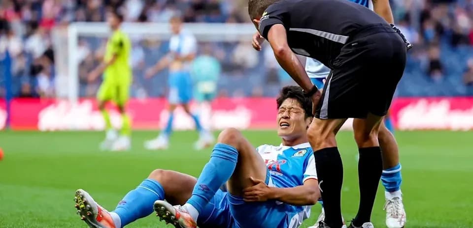 Player on the ground with referee checking injury