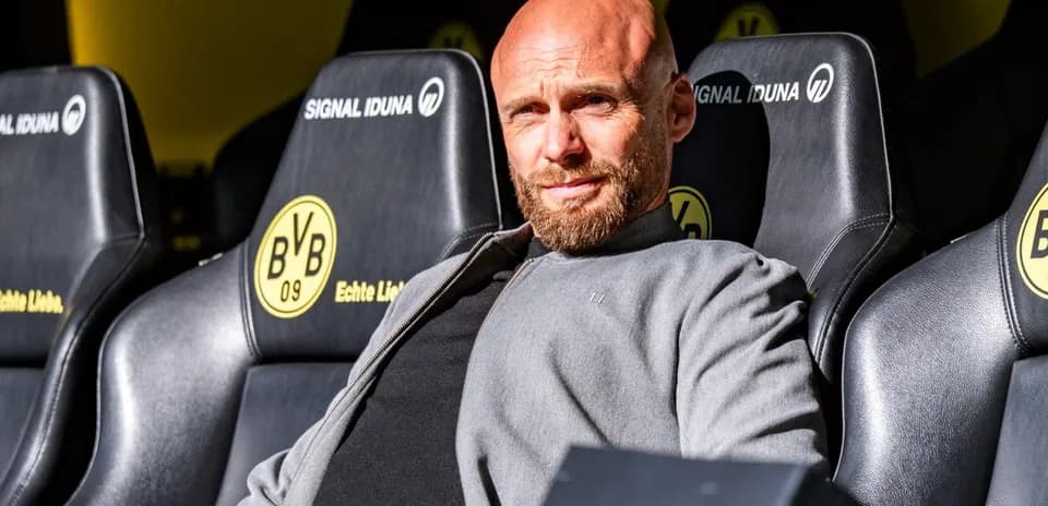 Coach seated on bench at stadium during match