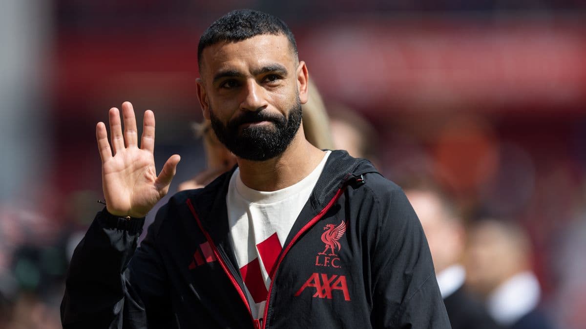 Player waving while wearing Liverpool FC jacket