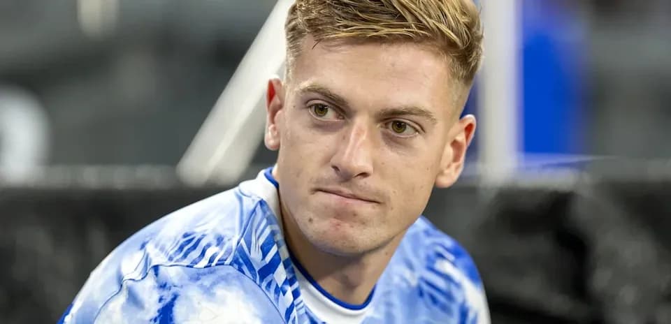 Player sitting on bench in blue team jersey