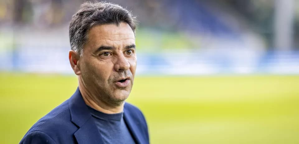 Coach speaking during pre-match interview on the field