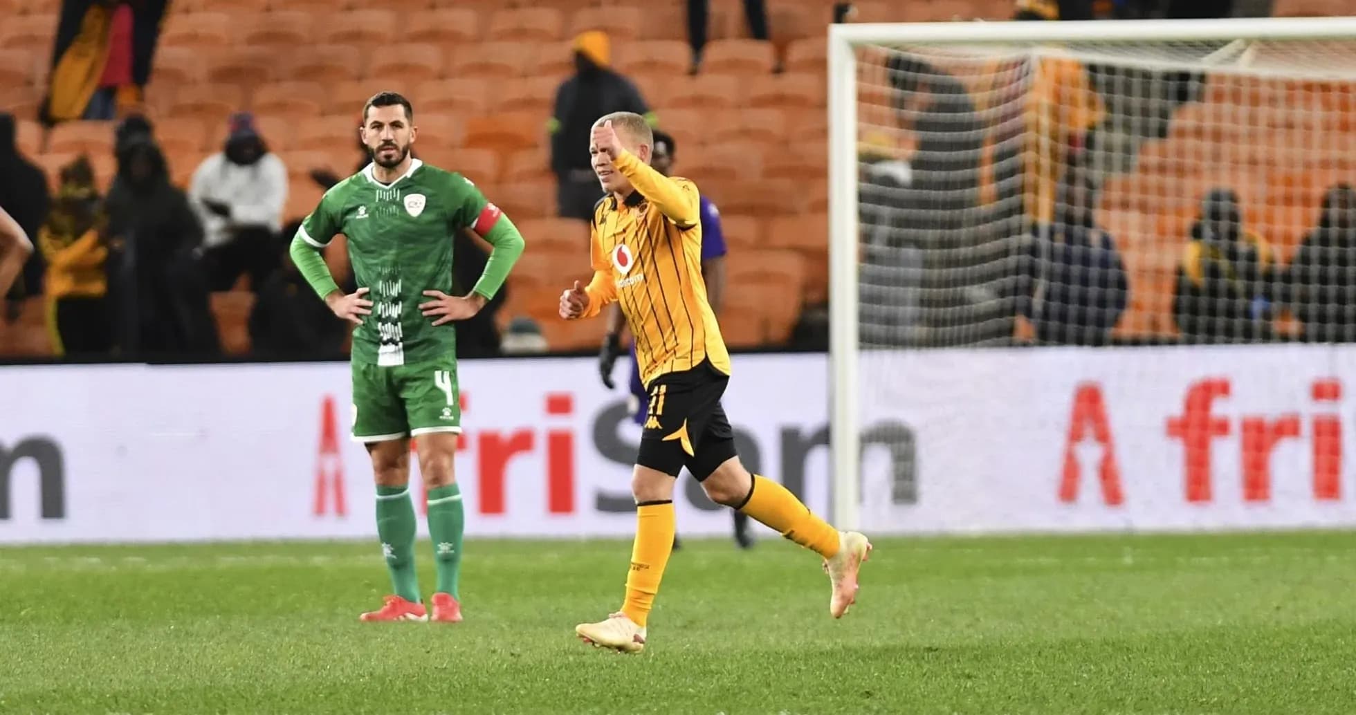 Player celebrating while opponent looks on in stadium