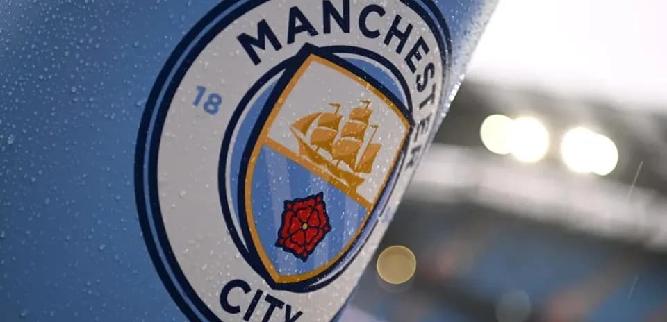 Close-up of Manchester City club logo with raindrops