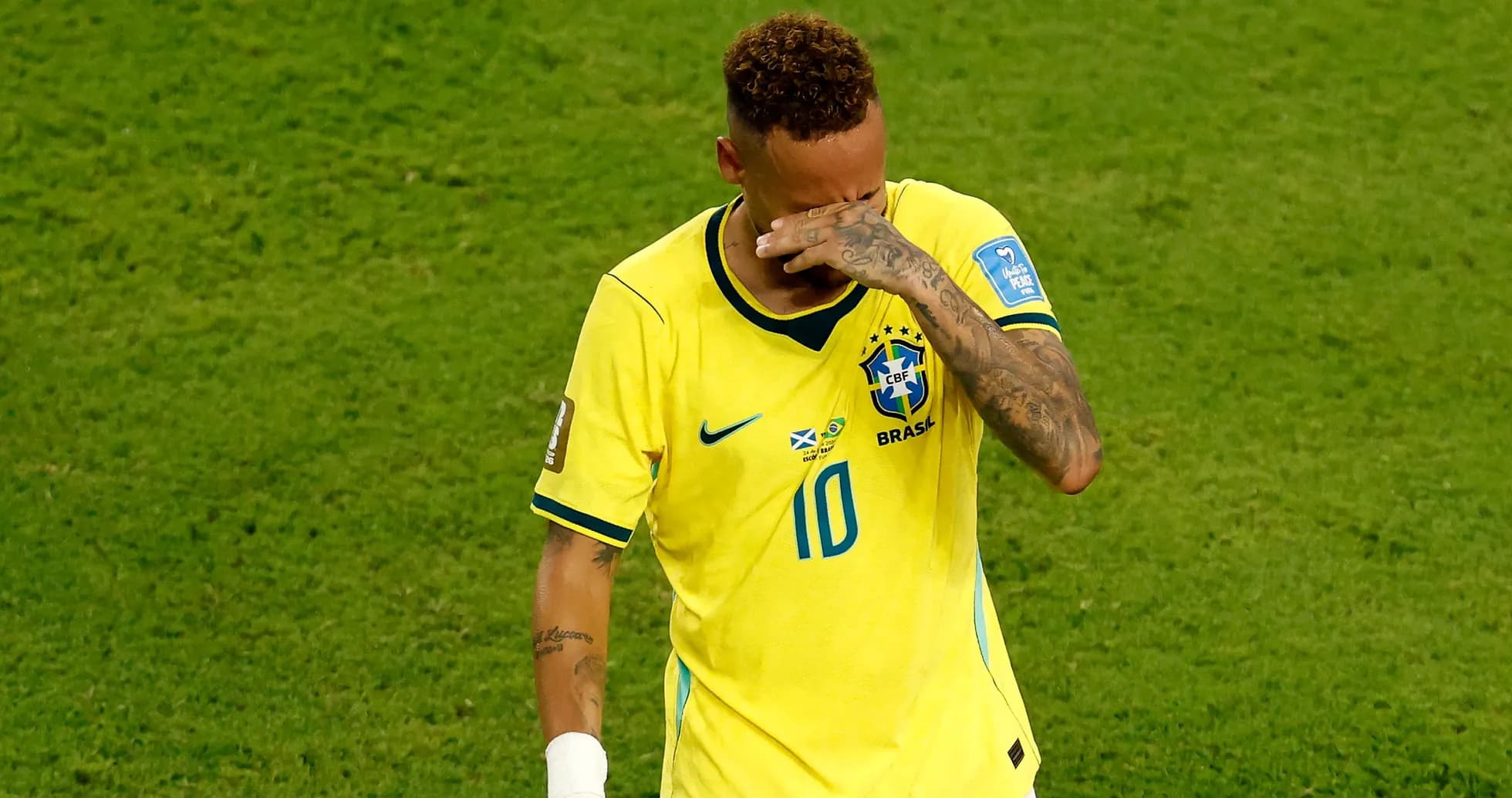 Player in Brazil jersey wiping his face
