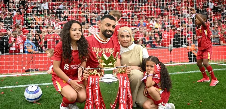 Player celebrating Premier League win with family and trophy