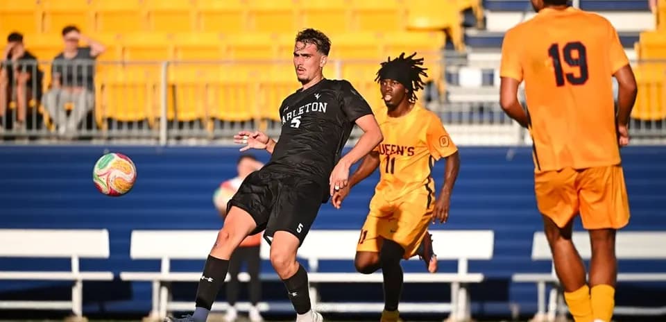 Player in black kicking ball during soccer match
