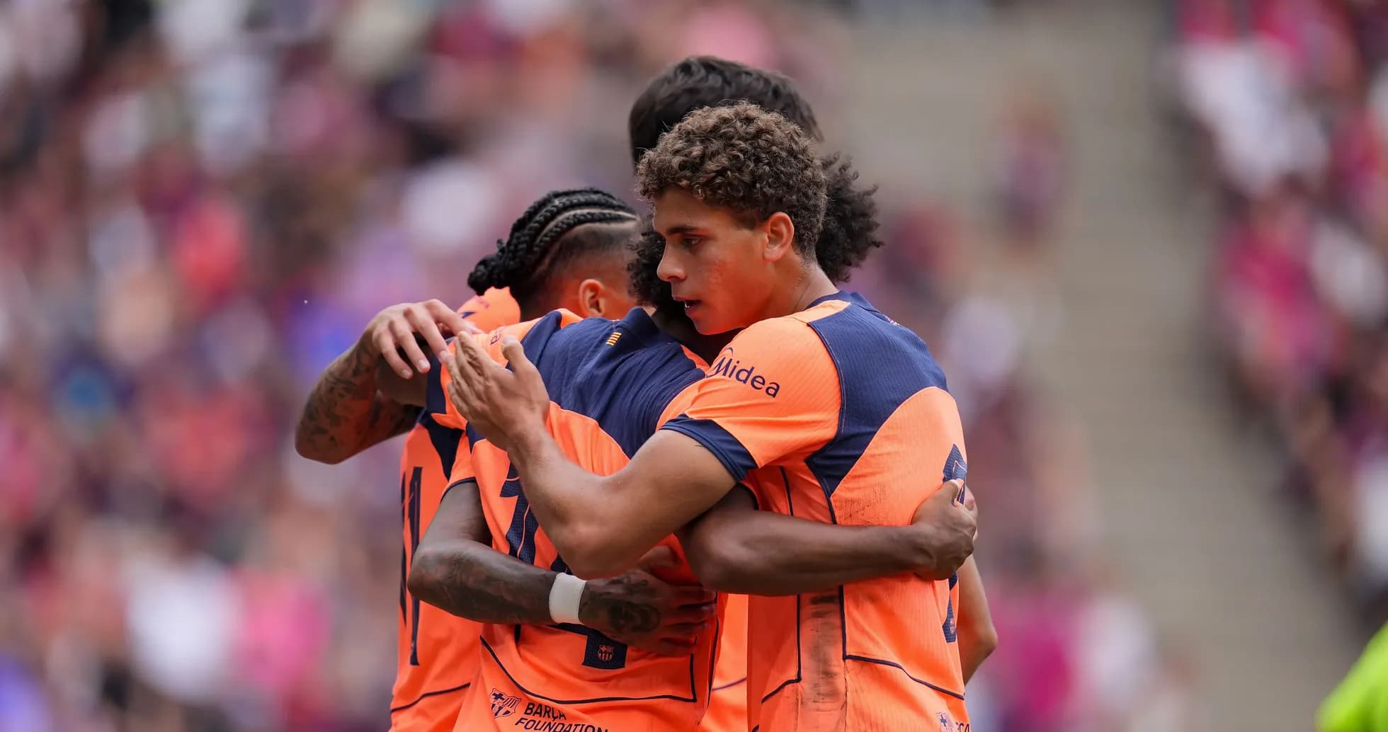Players celebrating in orange jerseys during match
