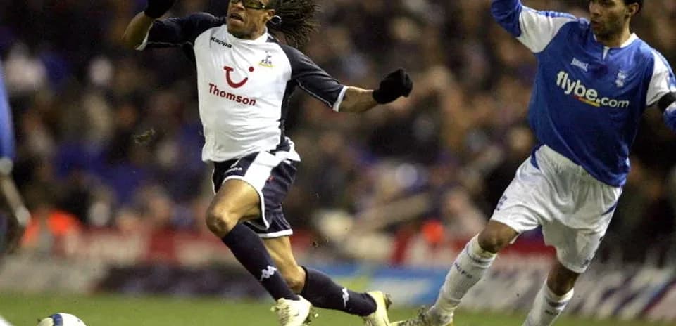 Player evading tackle during football match action