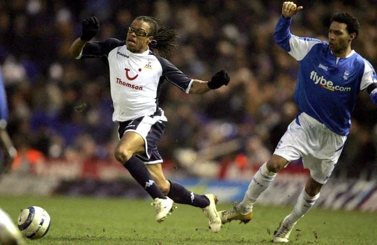 Player evading tackle during football match action