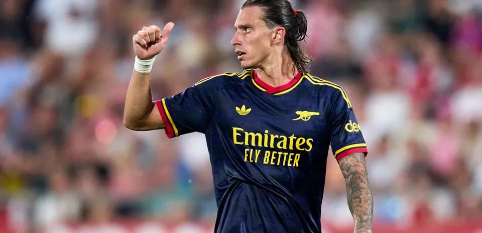 Player in Arsenal kit giving thumbs up on field