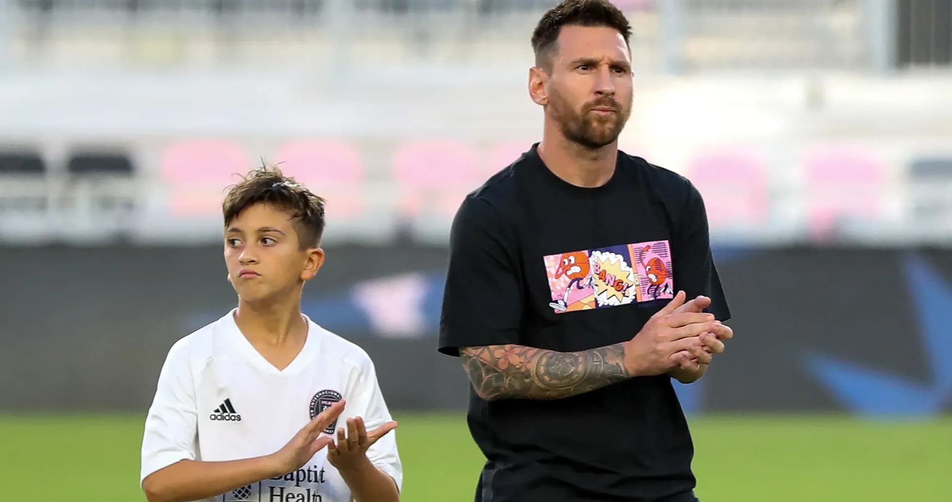 Lionel Messi and child clapping on field