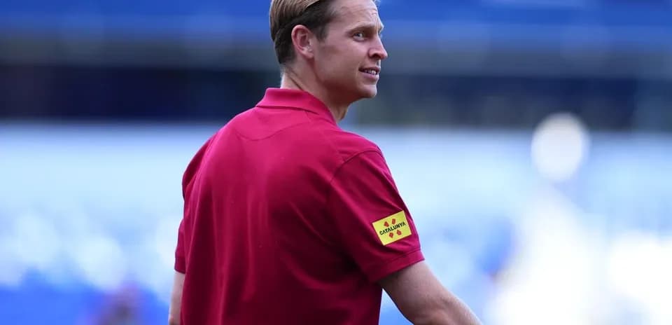 Official in red shirt observing the pitch