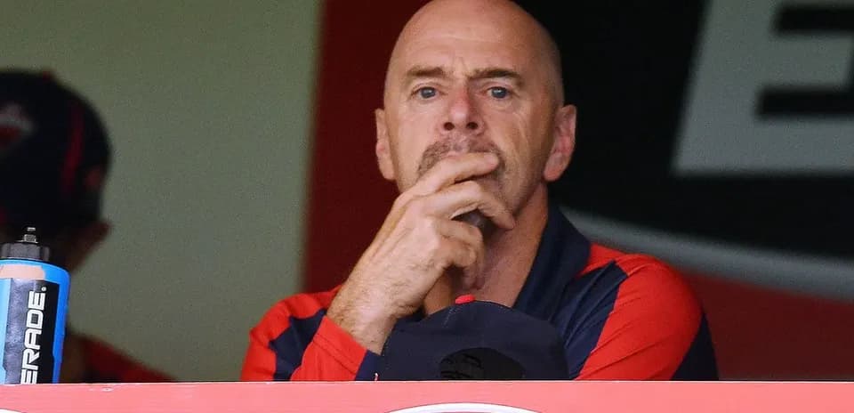 Coach observing the game from the dugout