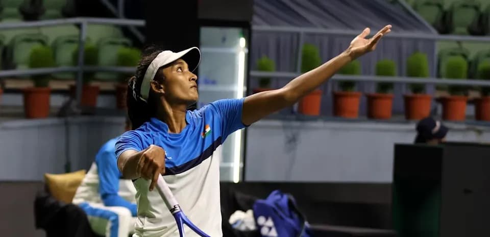 Female tennis player serving during practice session