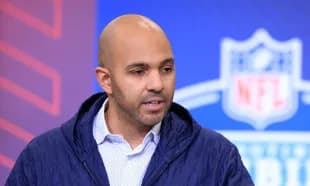 Man speaking at NFL event backdrop