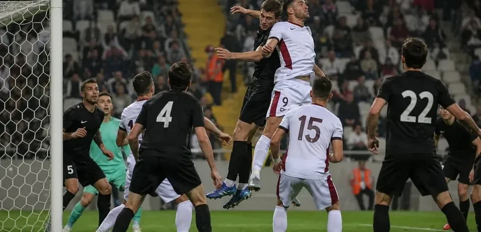 Players jumping for a header near the goal
