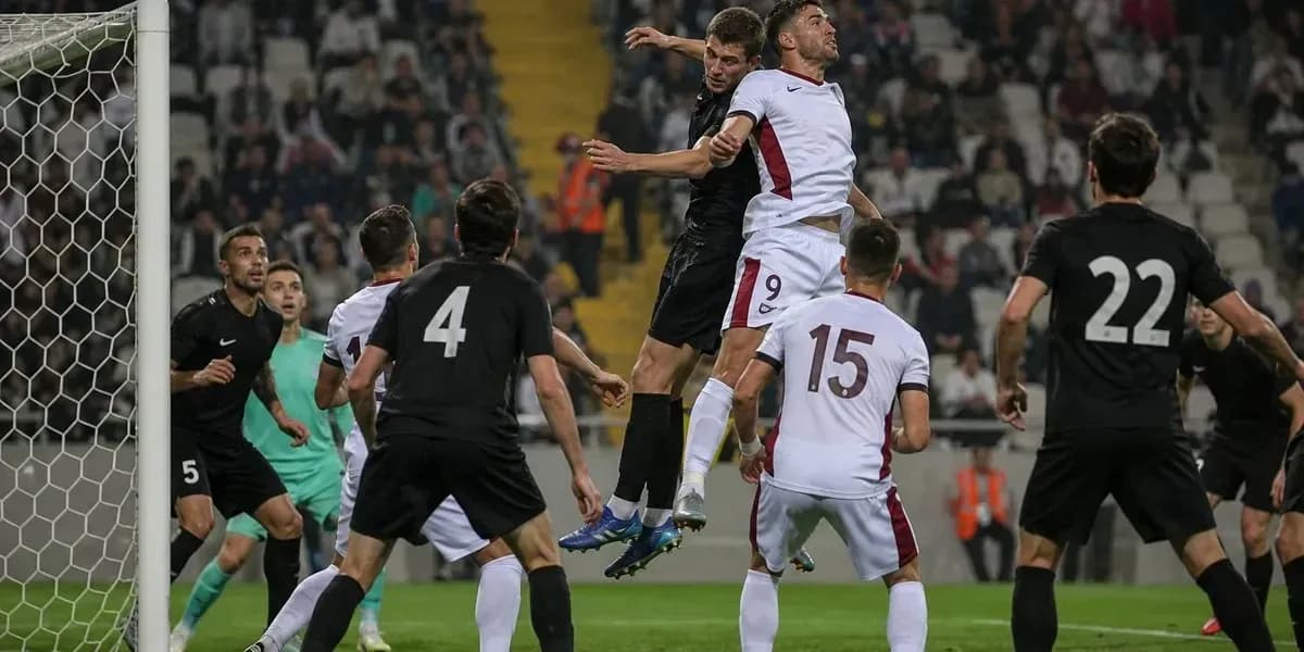 Players jumping for a header near the goal