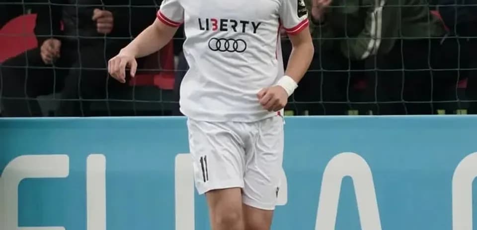 Player in white jersey dribbling ball on field