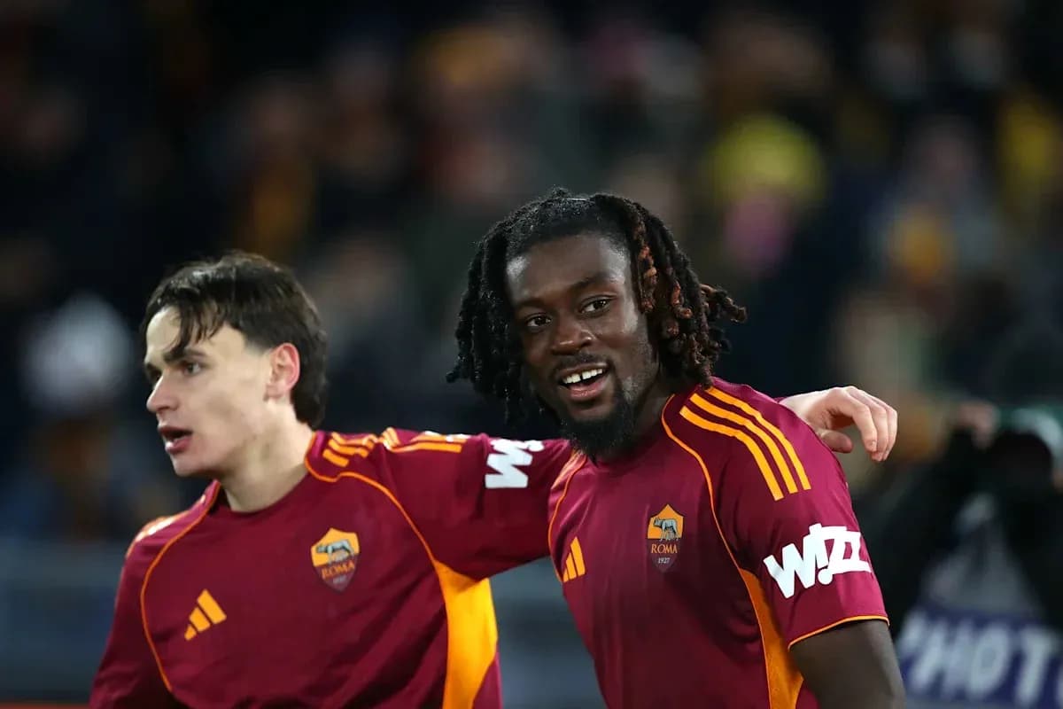 Two AS Roma players celebrating on the pitch