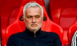 Manager seated on bench during match