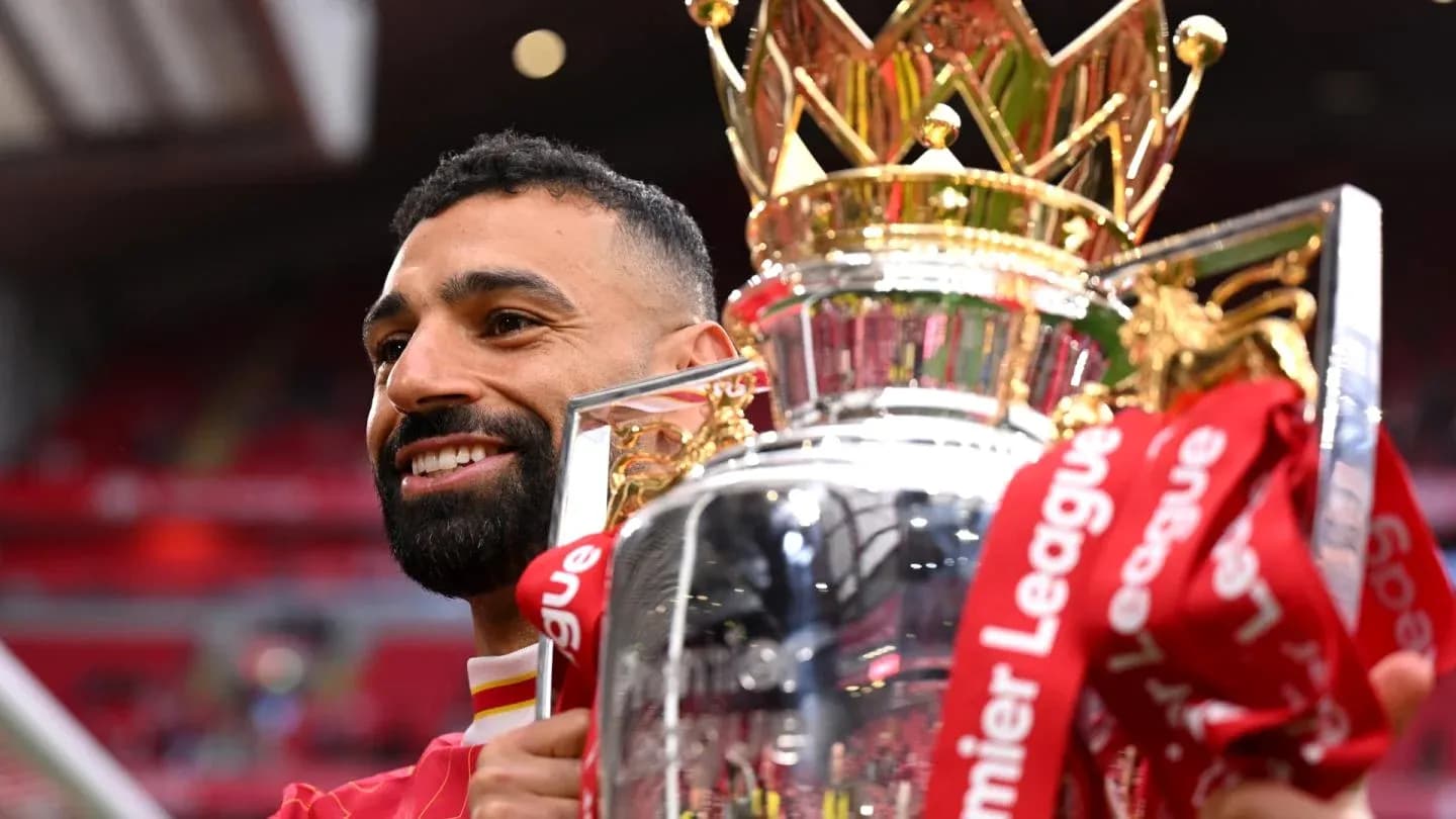 Player holding Premier League trophy at stadium