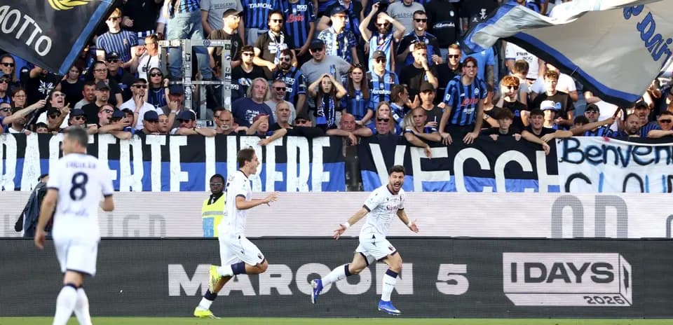 Players celebrating goal with fans in stadium