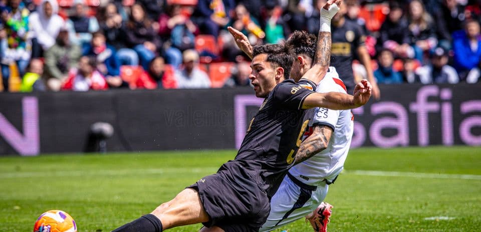 Player tackling opponent during Valencia match