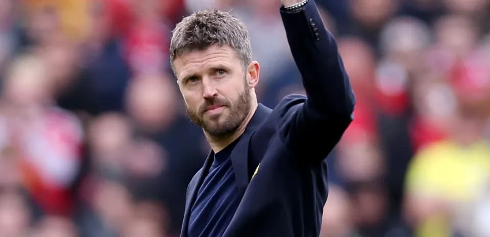 Coach waving to fans during a match