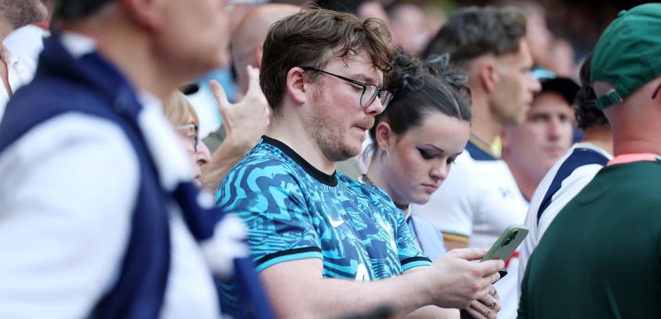 Fans watching the match, some using mobile phones