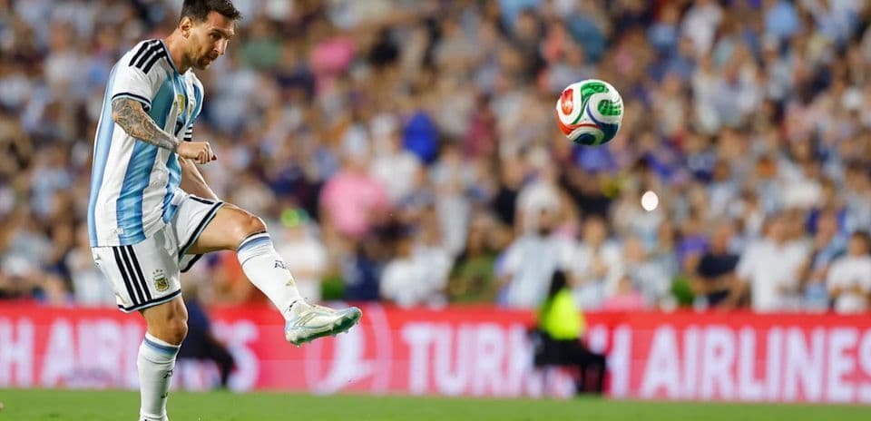 Lionel Messi preparing to kick a soccer ball
