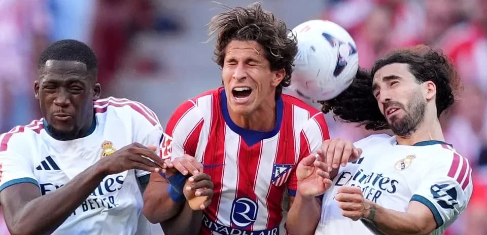 Players from Atlético and Real Madrid contesting a header