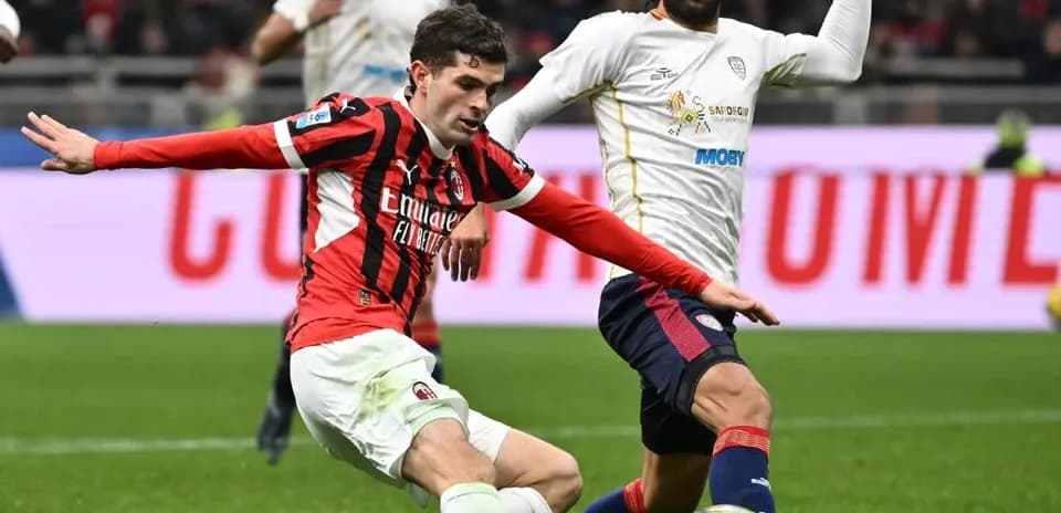 AC Milan player challenging Cagliari opponent