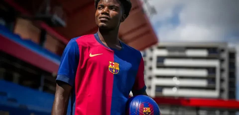 Player in Barcelona jersey holding a football