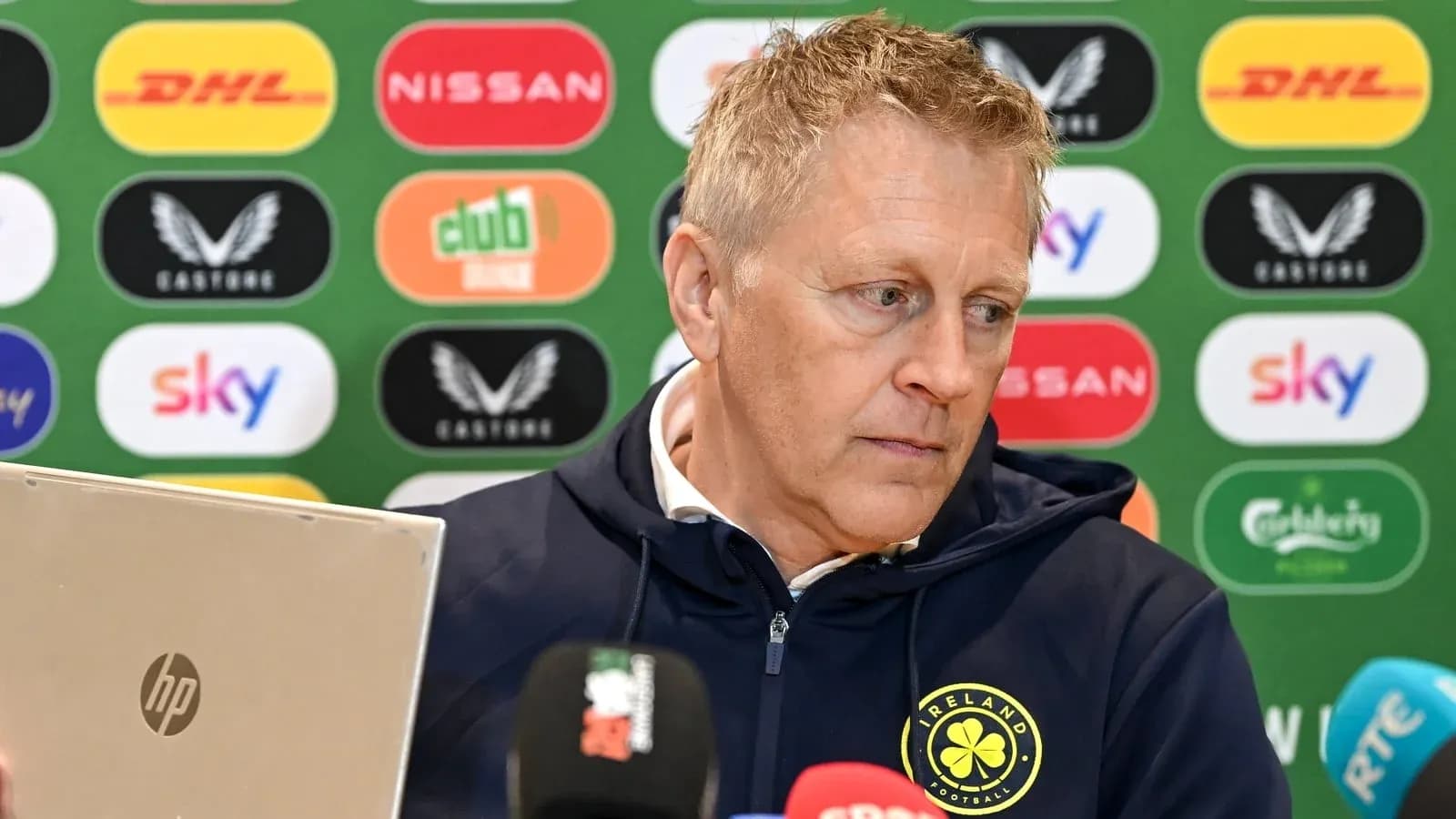 Manager at press conference with laptop and microphones