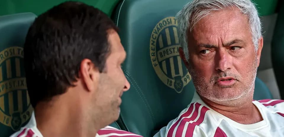 Two coaches discussing on the bench during match