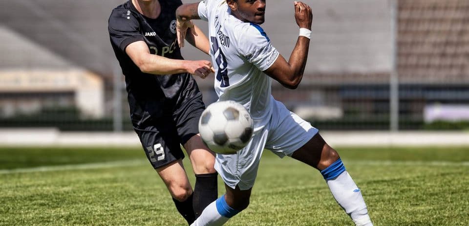 Player tackling opponent during Monheim vs Germania match