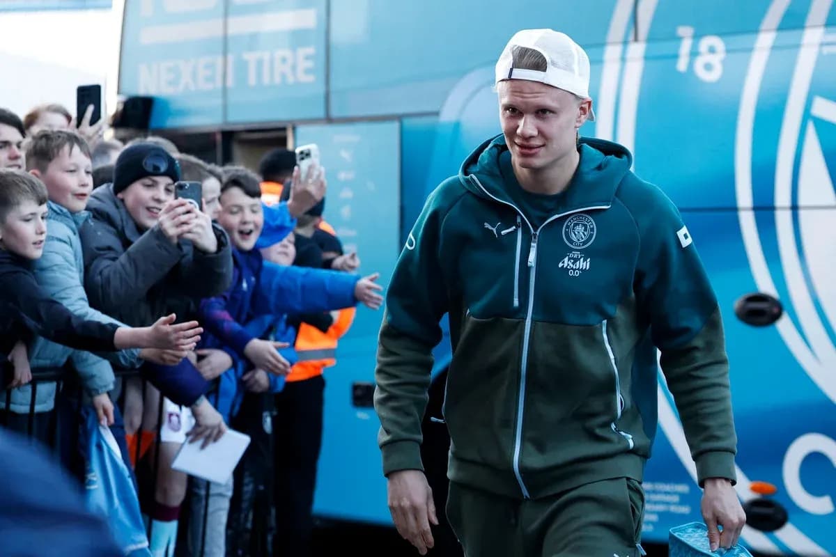 Player walking past fans outside team bus