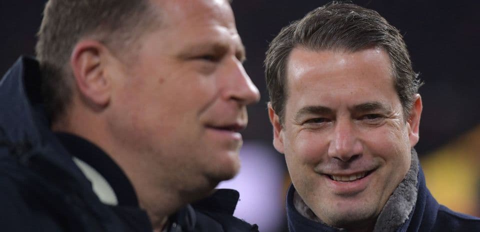 Two men smiling and talking on the sidelines