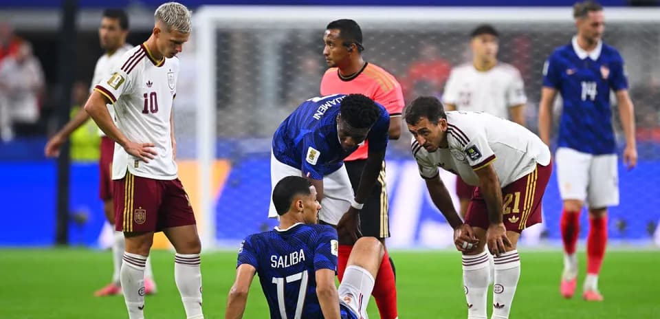 Players attending to injured player during match