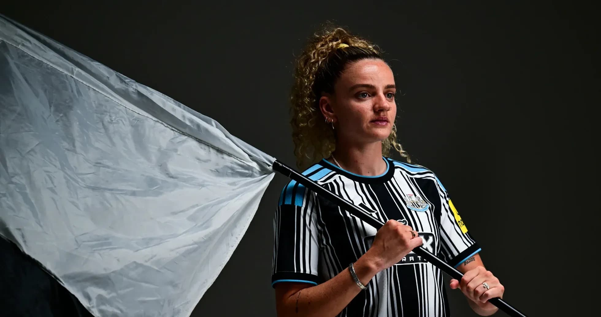 Player holding a flag wearing Newcastle jersey