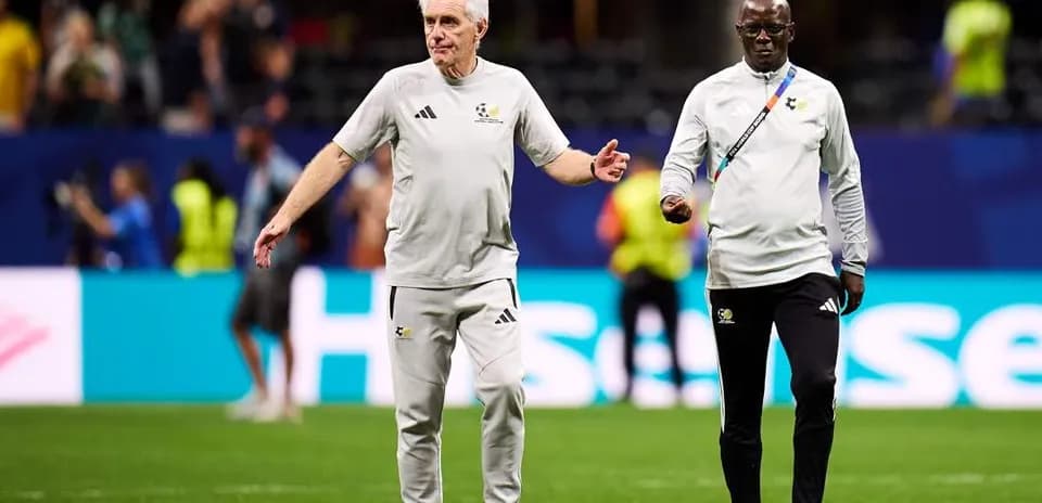 Two coaches walking on the pitch during warm-up