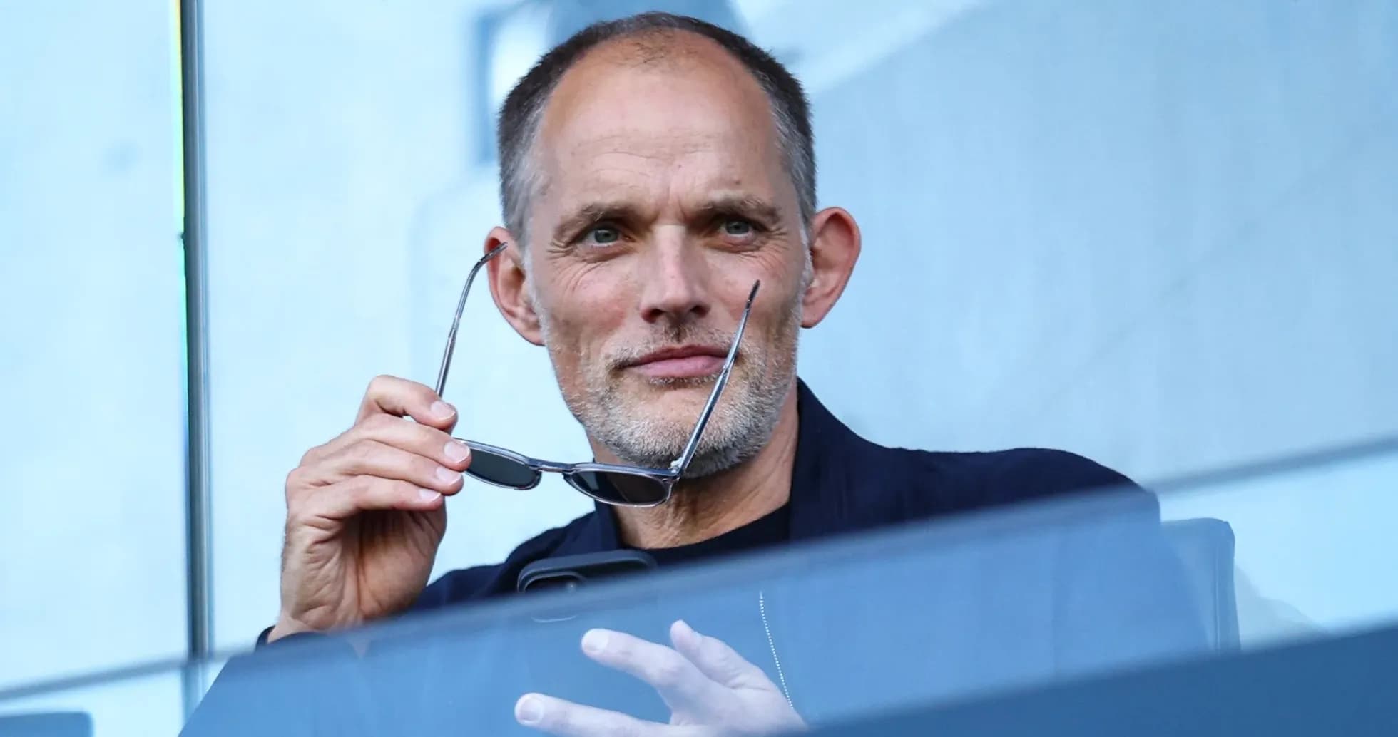 Man holding glasses in a stadium box